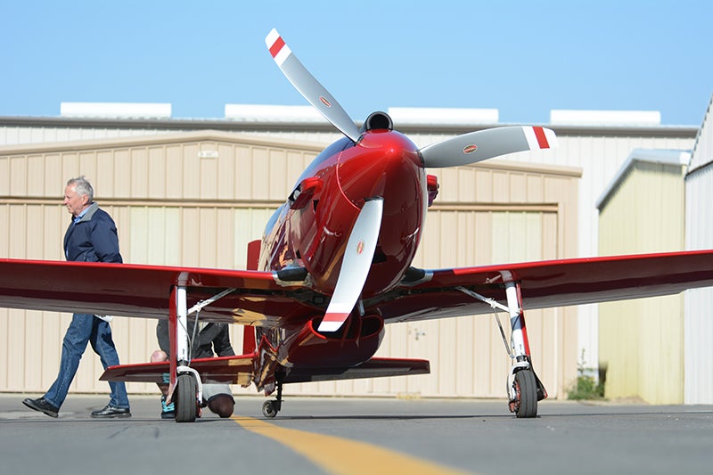 Crew chief Mike Brown walks behind the torpedo-like GP-5 during final preparations for the 3000 meter time-to-climb attempt. The scimitar Hartzell propeller is both quiet and efficient. It turns 2900 rpm, the Chevy V-8 6000 rpm.