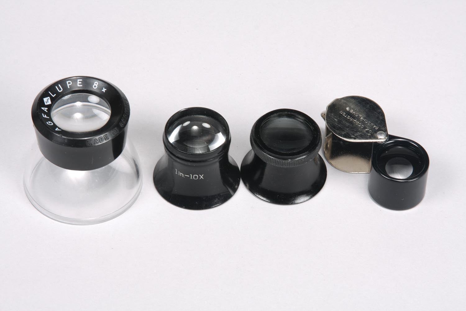 From left to right: A photographer’s loupe, two watchmaker’s loupes, and a folding pocket loupe.