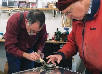 Rion Bourgeois (left) and Philip Groelz test the tank for leaks.