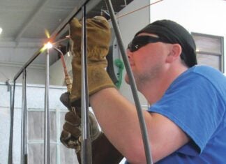 Aircraft welder using oxy-acetylene to weld an aircraft component.