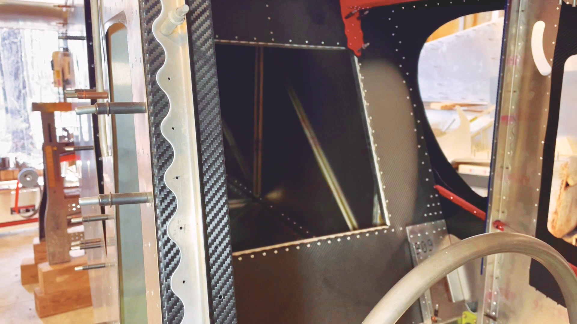 With the newly scalloped door trim Clecoed in place, you can still see the carbon fiber behind it.