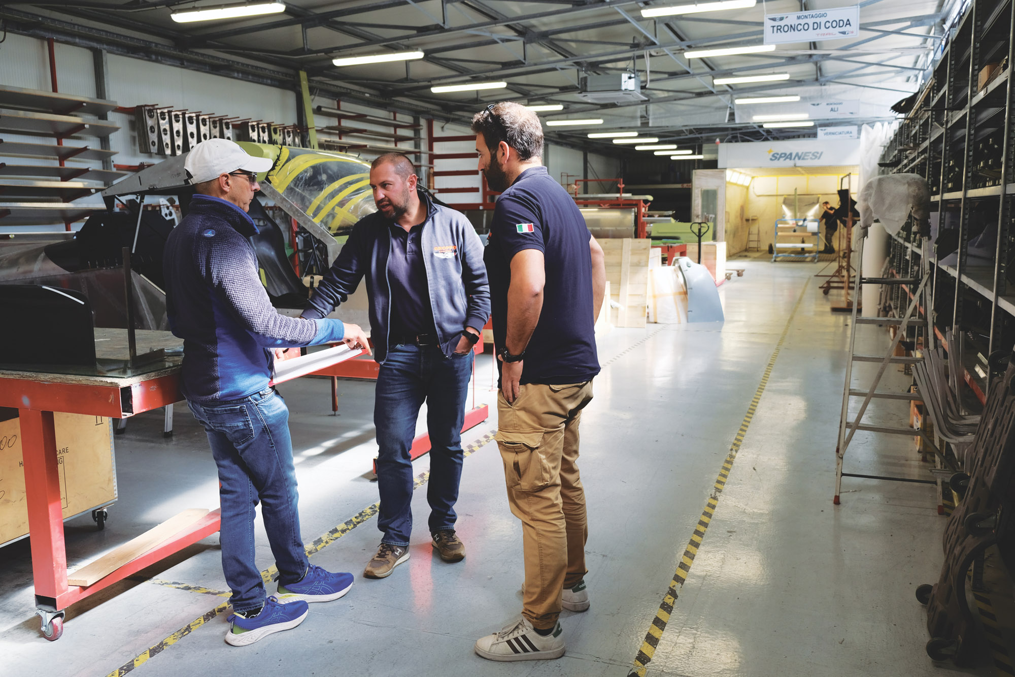 The author listens as Federico speaks in the kit production hangar.