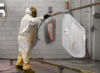 The painter sprays the door planels of a Glasair Sportsman 2+2. [Credit: Mike Davenport]