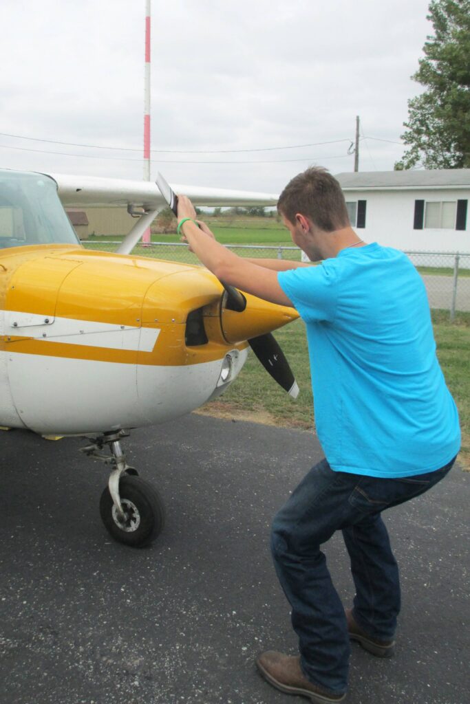 The alternative to bending down as the propeller is pulled through the compression stroke is to keep the back straight and bend the knees slightly, stepping away in a crouch. [Credit: LeRoy Cook]
