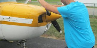 The alternative to bending down as the propeller is pulled through the compression stroke is to keep the back straight and bend the knees slightly, stepping away in a crouch. [Credit: LeRoy Cook]