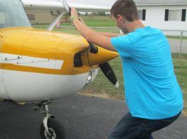 The alternative to bending down as the propeller is pulled through the compression stroke is to keep the back straight and bend the knees slightly, stepping away in a crouch. [Credit: LeRoy Cook]